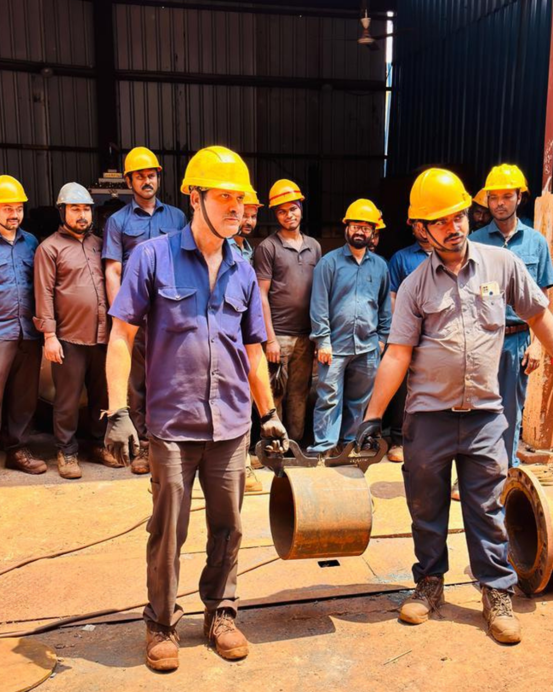 Workers using PSC manual lifting aids to carry a pipe section
